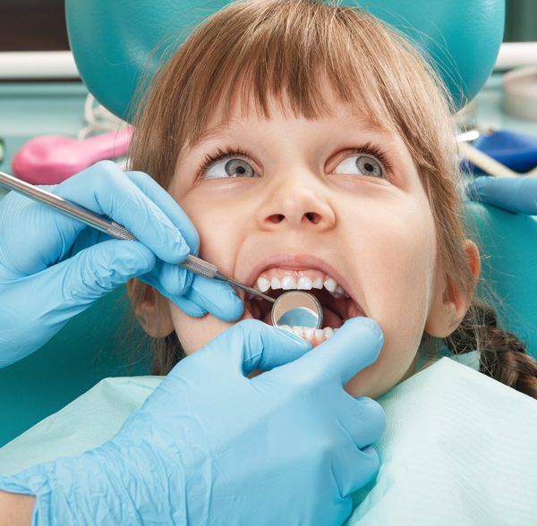 Little girl having her teeth checked at the dentist
